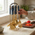 7 Pcs Stainless Steel Kitchen Tools Set Ceramic Handle displayed in a kitchen with gold and blue utensils on a countertop.