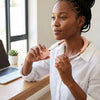 Woman using a Portable Hanging Neck Fan while working at a desk with a laptop, enjoying hands-free cooling.