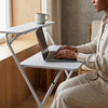 Person using a laptop on a Metal Legs Folding Computer Desk beside a window with a coffee cup.