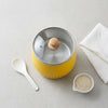 Remote Control Aromatherapy Fan in a bright yellow color with a wooden lid, surrounded by a spoon and rice.
