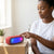 20W RGB Light Wireless Soundbox Speaker with colorful lights placed on a wooden table next to a woman.