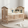 Wooden Baby Crib for Infants with Adjustable Mattress featuring soft bedding and decorative cushions.