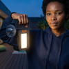 Woman holding a Solar-Powered Super Bright LED Searchlight, showcasing its bright LED light in an outdoor setting.