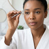 A woman in a white robe using a Veterinary Surgical Instrument Blade and Scalpel Handle for precise grooming.