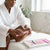 Woman in a white robe using the 6PCS Blister Card Manicure Kit to care for her feet at home.