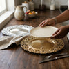 Person placing a plate on a 13-inch Eco-Friendly Charger Plate on a rustic wooden table.