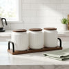 Ceramic Seasoning Jar Set with Wooden Tray on a kitchen counter with green napkin and modern decor.