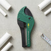 High Quality PVC Pipe Cutter Tool on a gray surface with white PVC pipes and a ruler.