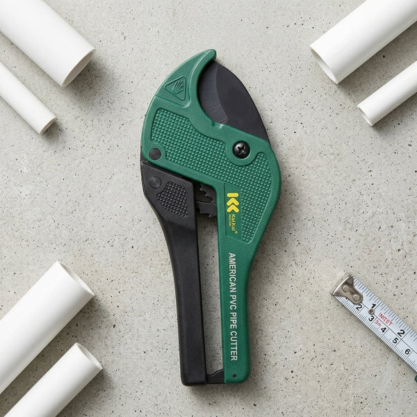 High Quality PVC Pipe Cutter Tool on a gray surface with white PVC pipes and a ruler.