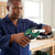 Man using High Quality PVC Pipe Cutter Tool to cut a white plastic pipe in a workshop.