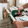 Person using a High Quality PVC Pipe Cutter Tool to cut white PVC pipe in a workshop setting.