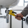 Person using Heavy-Duty 55mm Steel Adjustable Pipe Wrench to tighten plumbing under a sink.