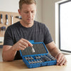 Man examining a tool from the 34-Piece Torx Socket and Bit Set in an organized blue case.