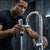 Man using 720 Degree Rotating Anti-Splash Faucet Aerator to direct water effectively at a modern sink.