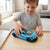 Child playing with a blue 1 32 Scale Diecast Pull Back Supercar on a wooden table.