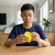 A boy focused on solving the Stress Reliever Fidget 3D Puzzle Cube at a wooden table, enhancing concentration.