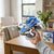 Person holding a Rotating Aircraft Friction Inertia Stunt Car in a modern living room setting.