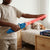 Child playing with LED Motion-Activated Kids Light-Up Saber Toy, featuring bright red lights in a bedroom setting.