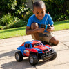 A boy enjoying the outdoors playing with a Children's Off-Road Jeep Ride Toy Car, navigating in a garden setting.