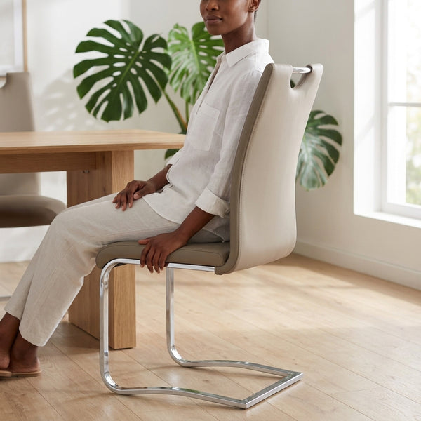 Cantilever Chrome Bar Stool with Backrest in a stylish setting with a woman seated beside a wooden table.