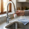Person adjusting the 360 Degree Adjustable Water Faucet Economizer on a modern kitchen sink.