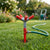 Garden Irrigation System with Adjustable 4-Arm Sprinkler in a lush green garden watering the lawn.