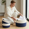 Man organizing towels in Cotton Rope Woven Storage Basket Suite in a modern living space.