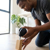 A person installing Universal Silent Swivel Luggage Replacement Wheels on a wooden base for repair.