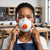 Woman adjusting FFP3 NR-D Face Respirator Mask in a workshop setting for respiratory protection.