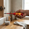 Person using the 5-Piece Insulated Magnetic Screwdriver Kit to tighten a cabinet hinge.