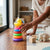 Child playing with Rainbow Tower Duck Stacking Ring Toy, featuring colorful rings and a yellow duck on top.