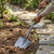 User using a Carbon Steel Round Point D Handle Shovel to dig in garden soil.