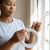 Woman holding 3M Flexible Aluminum Curtain Wire Cord and hook, ready to hang curtains.