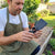 Man using a Carbon Steel Double Headed Garden Hoe-fork in a garden, showcasing its design and functionality.