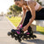 A woman adjusting her Adjustable 4 Wheel Inline Roller Skates while sitting on a bench in a park.