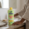 Double Dose Molato Skin Brightening Oil bottle on a bathroom counter with a hand reaching for it.