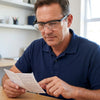 Man using Magnifying Eyewear with Transparent Display Box to read instructions at a desk.