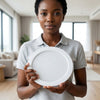 A woman holding a 12W Round LED Surface Panel Light in a modern indoor setting.