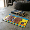 Tubeless Tire Repair Rubber Fixing Strips 10s packaging on a workbench with a tire and gloves in the background.
