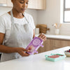 Person holding Silicone Paw and Smiley Face Ice Cream Moulds in a kitchen setting, preparing homemade frozen treats.
