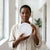A woman holding a 6W Round LED Surface Panel Light inside a bright indoor space.
