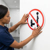 No Public Urination Warning Sign being installed on a bathroom door to promote cleanliness and proper behavior.