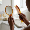 Classic Mirror and Comb Grooming Set featuring a tortoiseshell handheld mirror and comb on a bathroom counter.