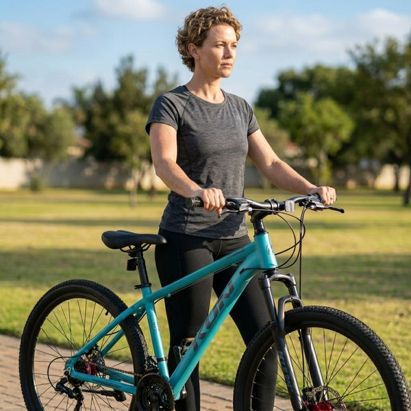 Full Suspension Enduro Mountain Bike with 160mm Travel, woman standing with bike in a park.