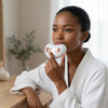 Woman using Electric Lip Plumper and Eye Massager Device for skincare routine at home.