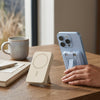 PD15W PD22.5W 10000mAh Magnetic Wireless Power Bank placed next to a smartphone on a wooden table with a coffee mug.