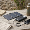 Multifunction Powerbank Folding Solar Panel 5W on wooden table with smartphone charging.