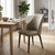 Taupe PU Leather Dining Chair with Gold-Tipped Legs in a modern dining space with wooden table and greenery.