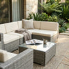 5-Piece Modular Rattan Outdoor Sectional Set arranged on a patio with a coffee table and decorative elements.