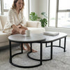 A woman sitting on a sofa, enjoying coffee at the Oval Shelf Coffee Table with Storage in a cozy living room.